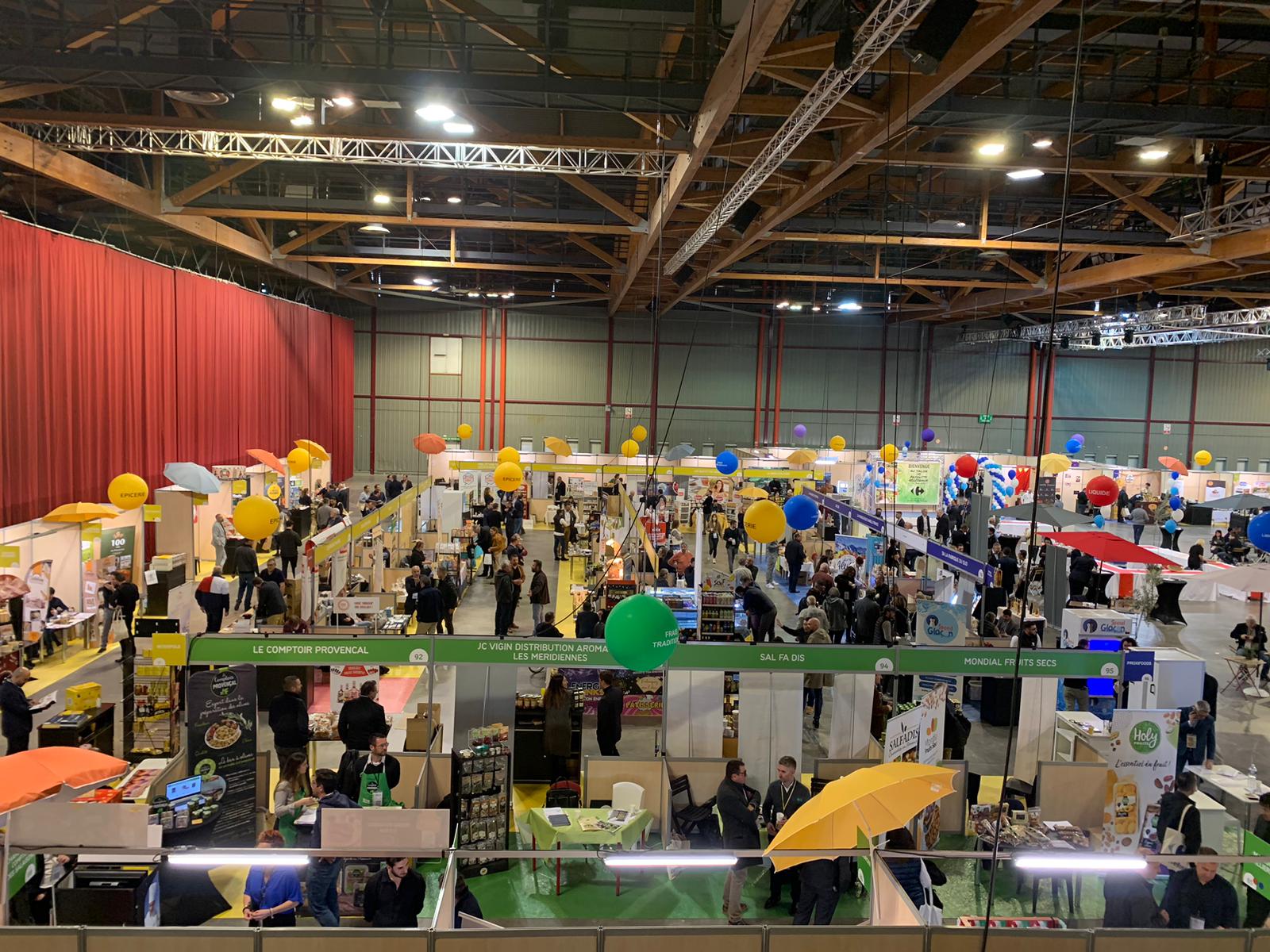 Visiteurs interagissant avec un stand ludique sur un salon